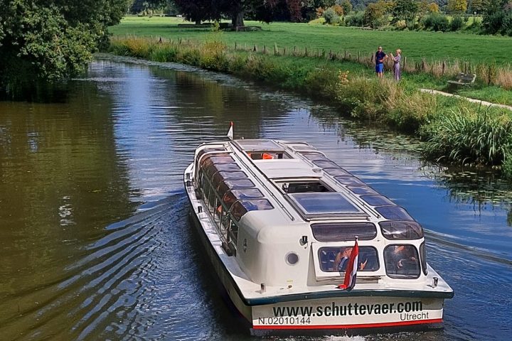 a boat traveling along a river next to a body of water