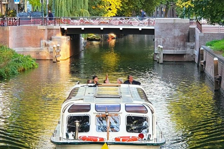 a boat floating along a river next to a body of water