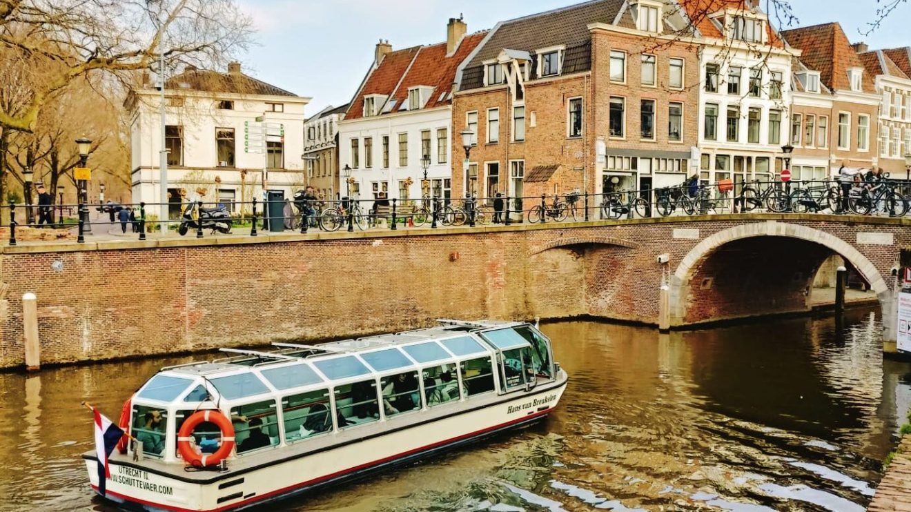 a boat floating along a river next to a body of water