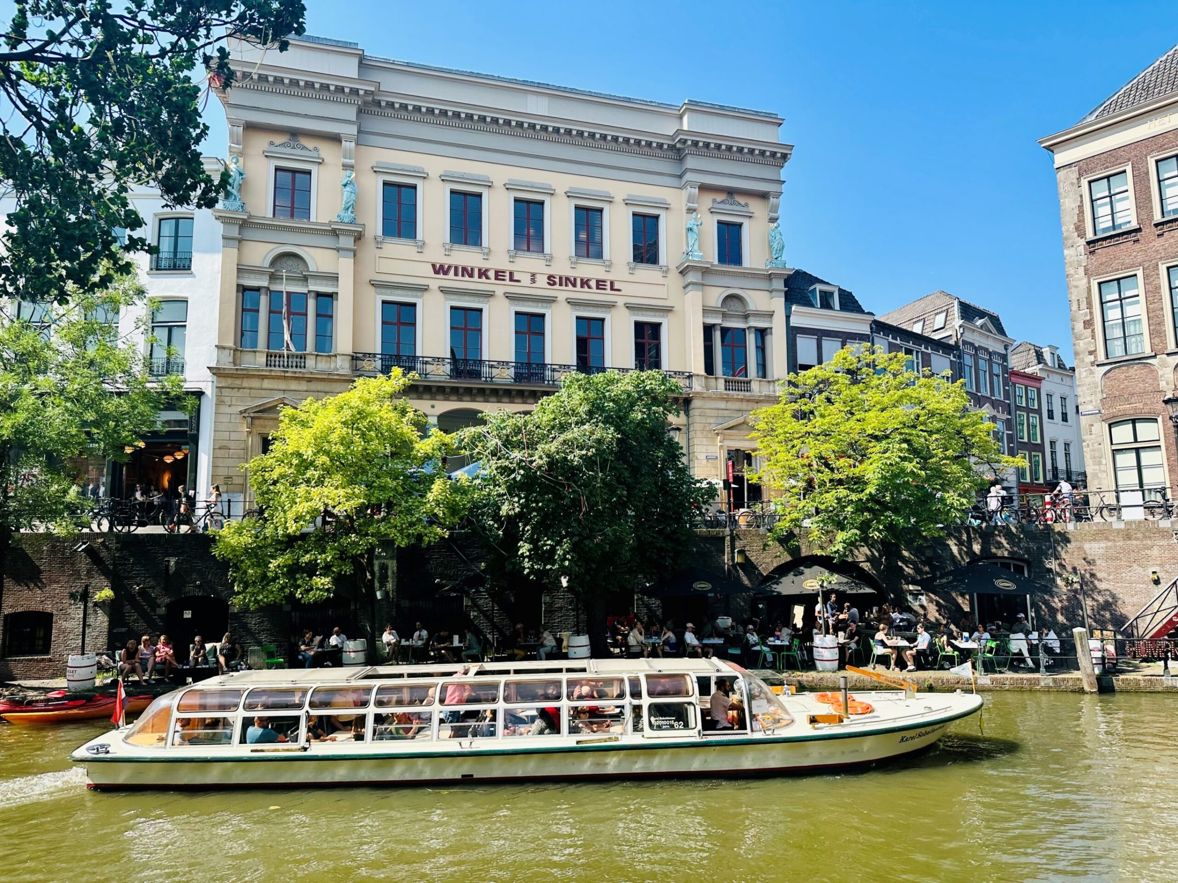 a boat floating along a river next to a body of water